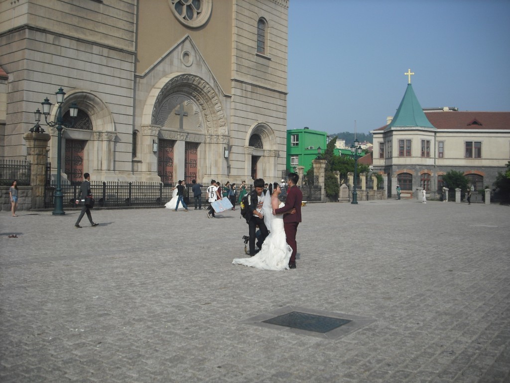 Qingdao was occupied by the Germans after WWI and some of the German architecture remains.  It's a popular wedding photo destination.  How many photo shoots do you spy in this picture??