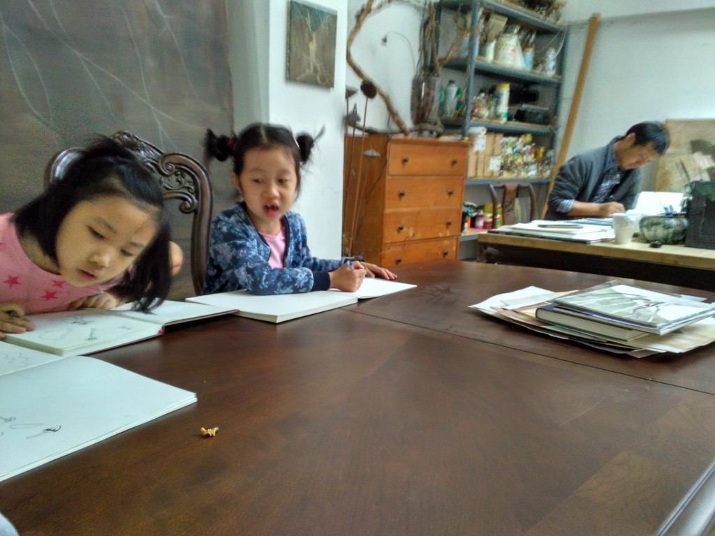 Drawing in their uncle's art studio with their friend (cousin?)