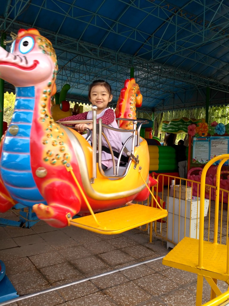 Sophia on the amusement ride at the park.