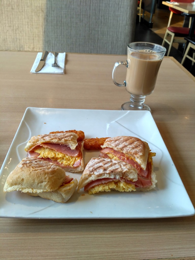 Ham and egg sandwich slices and a glass of milk tea.  Superb!